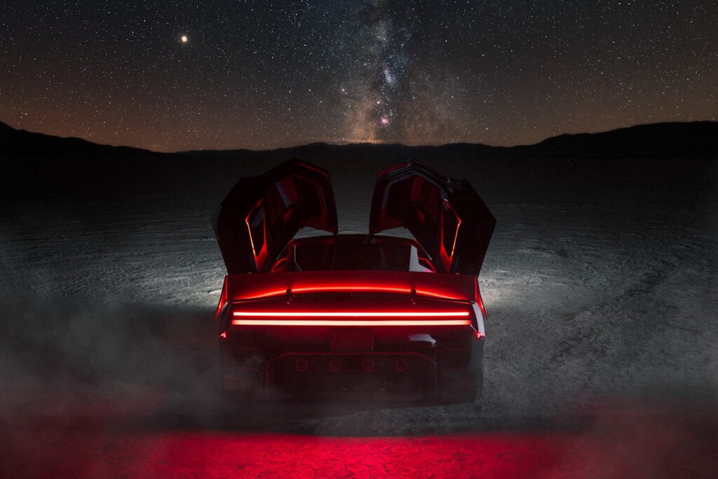 Traseira do novo Tesla Roadster com as portas abertas sob um céu estrelado